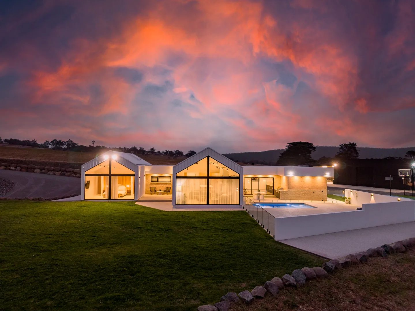 Modern house with illuminated windows at sunset