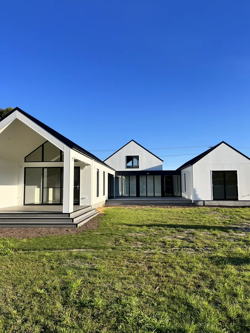 Modern farmhouse design with large windows and porch.