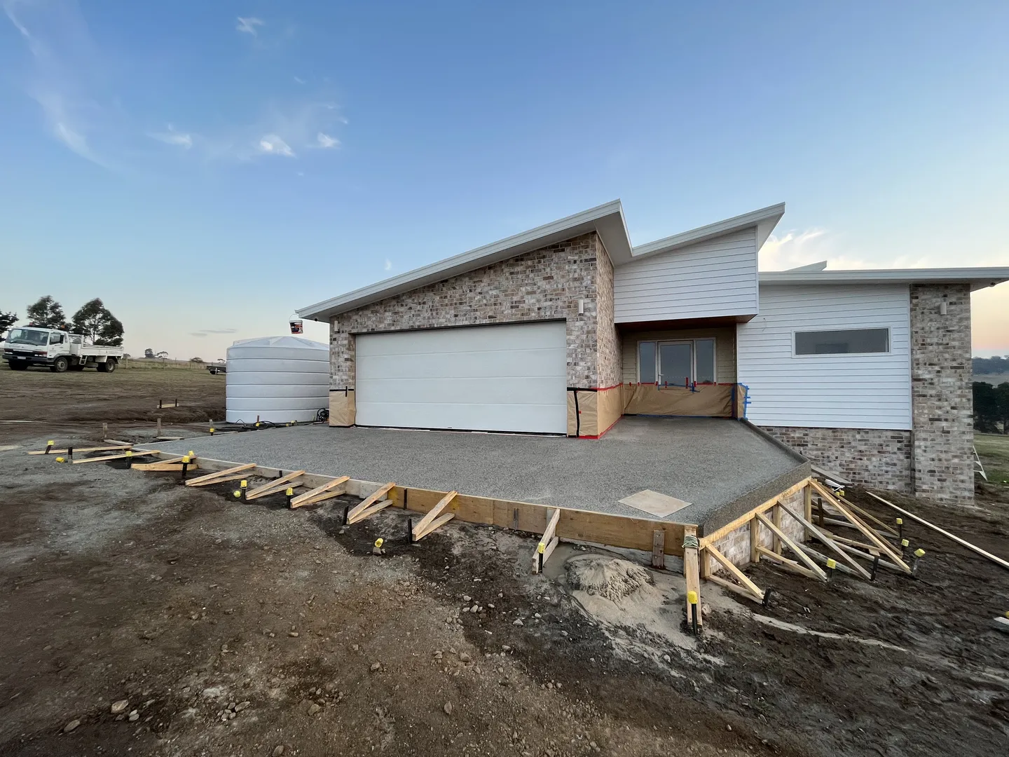 Modern house under construction with driveway foundation.